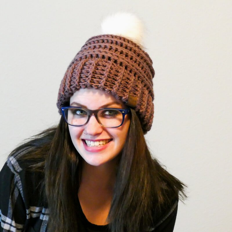 A woman wearing the crocheted Keystone Ribbed Hat with white background