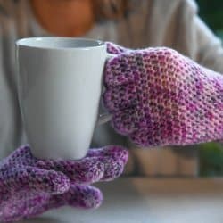 Photo of a person wearing the Easy Fit Lite Gloves with fingers while holding a white mug