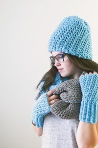 Photo of a woman wearing crochet scarf, bonnet, and fingerless gloves